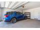 Spacious garage interior featuring a blue SUV parked inside with overhead storage and door at 18021 W Avenida Del Sol --, Surprise, AZ 85387