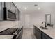 Modern kitchen with granite counters, stainless appliances, dark cabinets, and a convenient island at 18021 W Avenida Del Sol --, Surprise, AZ 85387
