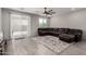Spacious living room with tile floors, large windows, and a comfortable leather sectional sofa at 18021 W Avenida Del Sol --, Surprise, AZ 85387