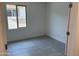 Neutral-toned bedroom with a large window for natural light, tile floors, and a crisp, clean aesthetic at 18165 W Larkspur Dr, Goodyear, AZ 85338