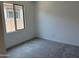 Neutral-toned bedroom with a large window for natural light, carpet floors, and a crisp, clean aesthetic at 18165 W Larkspur Dr, Goodyear, AZ 85338