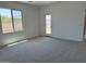 Neutral-toned bedroom with a large window for natural light, carpet floors, and a crisp, clean aesthetic at 18165 W Larkspur Dr, Goodyear, AZ 85338