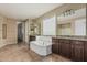 Bright bathroom with a soaking tub, dual vanities, tile flooring, and separate shower at 1915 S Ponderosa Dr, Gilbert, AZ 85295