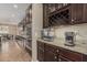 Modern kitchen features granite countertops, dark wood cabinets, stainless steel appliances, and a built-in wine rack at 1915 S Ponderosa Dr, Gilbert, AZ 85295