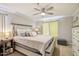 Bright bedroom with a ceiling fan, accent chair, and a cozy bed with decorative pillows at 2025 E Campbell Ave # 107, Phoenix, AZ 85016