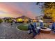 Backyard at twilight showcasing firepit, putting green and outdoor lights at 21084 E Cherrywood Dr, Queen Creek, AZ 85142