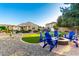 Spacious backyard with a fire pit, putting green, and ample seating for outdoor enjoyment at 21084 E Cherrywood Dr, Queen Creek, AZ 85142