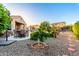 Expansive backyard with a covered patio, lush landscaping, and decorative rock at 21084 E Cherrywood Dr, Queen Creek, AZ 85142