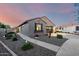 Lovely home with desert landscaping, sidewalk, and spacious three-car garage under a tranquil sunset sky at 21084 E Cherrywood Dr, Queen Creek, AZ 85142