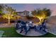 Evening shot of backyard area featuring a firepit with blue Adirondack chairs at 21084 E Cherrywood Dr, Queen Creek, AZ 85142