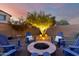 Cozy fire pit area at dusk, surrounded by Adirondack chairs and landscape lighting at 21084 E Cherrywood Dr, Queen Creek, AZ 85142