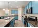 The kitchen features an island, blue cabinetry, stainless appliances and lots of countertop space at 21084 E Cherrywood Dr, Queen Creek, AZ 85142