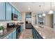 An angle of the kitchen highlighting blue cabinets, stainless appliances, and the granite island at 21084 E Cherrywood Dr, Queen Creek, AZ 85142