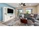 Bright living room featuring a built-in entertainment center, sectional sofa, and access to the backyard at 21084 E Cherrywood Dr, Queen Creek, AZ 85142