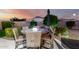 Outdoor dining table with seating amidst lush landscaping and nighttime lighting for evening gatherings at 21084 E Cherrywood Dr, Queen Creek, AZ 85142