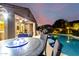 Wonderful backyard pool area with outdoor dining and poolside seating, all illuminated by stylish lighting at 21084 E Cherrywood Dr, Queen Creek, AZ 85142