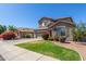 Charming two-story home featuring shutters, a well-maintained lawn, and beautiful landscaping at 2152 W Sunshine Butte Dr, San Tan Valley, AZ 85144