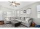 Comfortable living room features a large sofa, ceiling fan, and lots of natural light at 2152 W Sunshine Butte Dr, San Tan Valley, AZ 85144