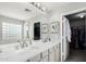 Bright main bathroom features dual sinks, custom cabinets, and glass enclosed shower at 2152 W Sunshine Butte Dr, San Tan Valley, AZ 85144