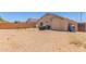 Wide backyard featuring a rock ground cover, block fence, and desert landscaping at 22534 W Pima St, Buckeye, AZ 85326