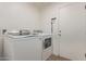 Well-lit laundry room featuring a modern washer and dryer, plus a utility door at 22534 W Pima St, Buckeye, AZ 85326