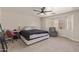 Main bedroom featuring a ceiling fan, carpeted floor, a chair, and a large window for natural lighting at 22534 W Pima St, Buckeye, AZ 85326