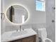 Stylish bathroom featuring modern vanity, circular mirror, and tiled shower at 22548 W Huntington Dr, Buckeye, AZ 85326
