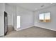 Well-lit bedroom with neutral carpet, large window, and connected hallway at 22548 W Huntington Dr, Buckeye, AZ 85326