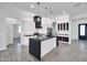 Bright kitchen with black countertops, stainless appliances, island with pendant lights and open layout to living spaces at 22548 W Huntington Dr, Buckeye, AZ 85326
