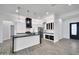 Bright kitchen with black countertops, stainless appliances, island with pendant lights and an open layout to living space at 22548 W Huntington Dr, Buckeye, AZ 85326
