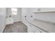 Clean laundry room with a sink, white cabinetry, and granite countertops at 22548 W Huntington Dr, Buckeye, AZ 85326
