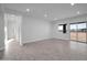 Spacious living room with sleek flooring, recessed lighting, and sliding glass doors to the outside at 22548 W Huntington Dr, Buckeye, AZ 85326