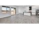 Bright living room and kitchen combo featuring sleek floors and a sliding glass door for outdoor access at 22548 W Huntington Dr, Buckeye, AZ 85326