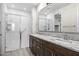 Modern bathroom features a double sink vanity with granite countertops and a sleek glass shower at 24953 N 172Nd Dr, Surprise, AZ 85387