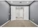 Spacious bedroom with neutral walls, carpet flooring, and double doors leading to hallway at 24953 N 172Nd Dr, Surprise, AZ 85387
