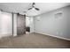 Spacious bedroom featuring a modern ceiling fan and a stylish sliding barn door to the ensuite bathroom at 24953 N 172Nd Dr, Surprise, AZ 85387