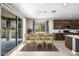 This dining room features a sliding door and a table set for six guests, with dark wood cabinets in the background at 24953 N 172Nd Dr, Surprise, AZ 85387