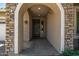 Covered entryway with arched stonework and dark wood door at 24953 N 172Nd Dr, Surprise, AZ 85387
