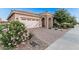 Charming single-story home with a brick-paved driveway and stone-accented entryway at 24953 N 172Nd Dr, Surprise, AZ 85387