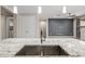 A spacious kitchen island with a sink, perfect for food prep and socializing, with views into other rooms at 24953 N 172Nd Dr, Surprise, AZ 85387