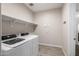 Laundry room complete with washer, dryer, shelving and vinyl flooring at 24953 N 172Nd Dr, Surprise, AZ 85387