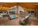 Inviting outdoor lounge area with comfortable seating, a stone fireplace, and a stylish vaulted ceiling at 24953 N 172Nd Dr, Surprise, AZ 85387