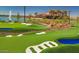 Scenic putting green area with sand traps and landscaping beside a lake, perfect for leisurely play and relaxation at 24953 N 172Nd Dr, Surprise, AZ 85387