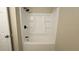 Bathroom featuring a tub and shower combo with a sleek black shower head and built-in shelving at 2548 E Encanto St, Mesa, AZ 85213