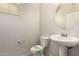 Half bath featuring a pedestal sink, toilet, and modern fixtures at 2640 N 73Rd Gln, Phoenix, AZ 85035