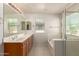 Bright bathroom with double sinks, bathtub, and glass-enclosed shower at 2640 N 73Rd Gln, Phoenix, AZ 85035