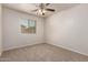 Cozy bedroom featuring carpeted floors, a ceiling fan, and a window at 2640 N 73Rd Gln, Phoenix, AZ 85035