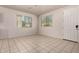 Bright living room with tile flooring, two windows, and a white front door at 2640 N 73Rd Gln, Phoenix, AZ 85035