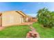 Lush backyard featuring a covered patio, stone walkway, green grass and a mature palm tree at 2783 E Mineral Park Rd, San Tan Valley, AZ 85143
