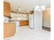 Functional kitchen featuring wood cabinets, white appliances, and tiled floors at 2783 E Mineral Park Rd, San Tan Valley, AZ 85143